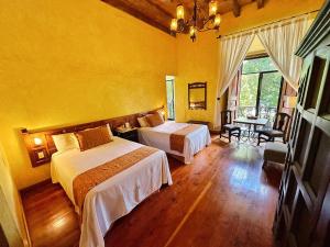 a hotel room with two beds and a television at Hotel Ciudad Real Centro Historico in San Cristóbal de Las Casas