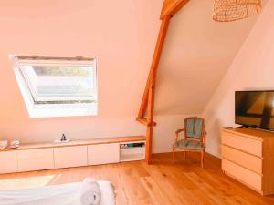 a room with a bed and a television and a chair at Loft room heerenhuys in Eeklo