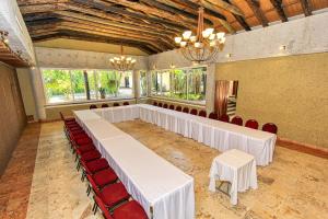 a banquet hall with white tables and red chairs at Hotel Ciudad Real Palenque in Palenque +108 photos