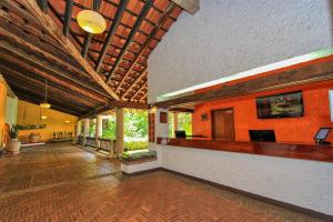 a large room with a lobby with orange walls at Hotel Ciudad Real Palenque in Palenque