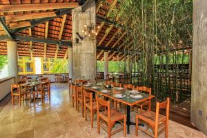 a dining room with a long table and chairs at Hotel Ciudad Real Palenque in Palenque