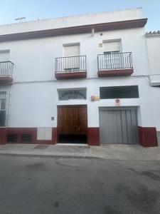 a white building with two doors and two balconies at apartamento Atlanta in Chipiona