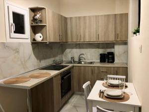 eine Küche mit Holzschränken, einem Tisch und einer Spüle in der Unterkunft Eva's Sweet Home in Thessaloniki + 7 Fotos