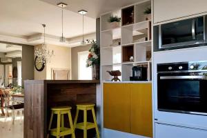 a kitchen with a counter and stools in a room at Verão dos Sonhos no Condomínio Dubai Resort in Capão da Canoa