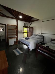 a bedroom with two beds and a piano in it at Casa Pomar do Aconchego in Paraty