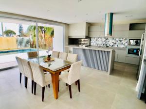 eine Küche und ein Esszimmer mit Tisch und Stühlen in der Unterkunft Casa de Luxo Decorada no Condomínio La Plage in Xangri-lá