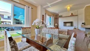 un salon avec une table en verre et un canapé dans l'établissement Casa de Verão dos Sonhos no Las Palmas, à Xangri-lá