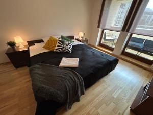 Un dormitorio con una cama grande con una manta negra. en Old Town Apartments - free parking Przemysłowa str, en Cracovia
