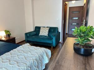 sala de estar con sofá verde y silla en Old Town Apartments - free parking Przemysłowa str, en Cracovia