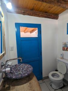 a bathroom with a blue door and a toilet at Casapueblo in Cachí