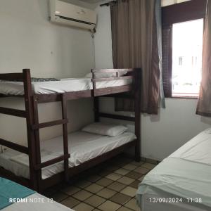 a room with three bunk beds and a window at Rô Hostel Cabo Branco in João Pessoa