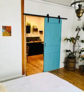 a blue door in a bedroom with a desk at Gîte des Sisampas- Terrasse privée, vue aux montages in Rencurel