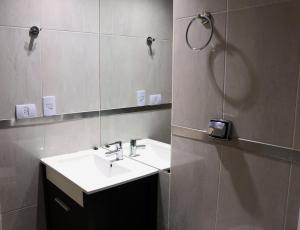 un baño con lavabo y espejo en Amplio monoambiente con piscina, en Buenos Aires 8 fotos más