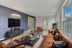 Una sala de estar con un sofá y un televisor de pantalla plana. en Magical beach bungalow getaway!, en Ormond-by-the-Sea