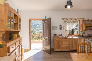 cocina con nevera y puerta con ventana en Casa Abuela - Pool House in the countryside, en Vega de San Mateo