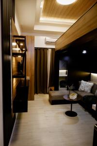 a living room with a couch and a table at Kozen at Azure North Pampanga in San Fernando