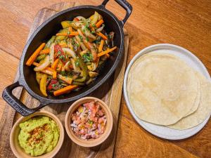 a pan of food with vegetables and other dishes on a table at Viajero Arequipa Hostel in Arequipa +55 photos