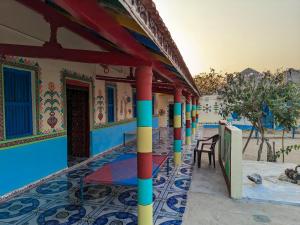 a house with colorful columns in front of a building at White Land Villagestay in Dhordo