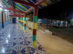 a row of colorful poles on a tiled floor at White Land Villagestay in Dhordo