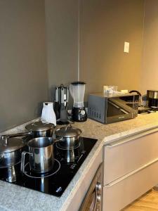 a kitchen counter with pots and pans on a stove at LK Santo Agostinho 2 in Belo Horizonte
