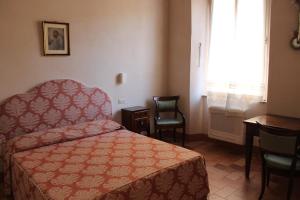 a bedroom with a bed and a table and a window at Palazzo Trevisani in Porto San Giorgio +8 photos