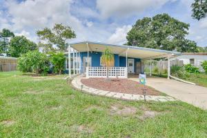 a house with a palm tree in front of it at Mins from Anna Maria Island Bright Home with Pool! in Bradenton