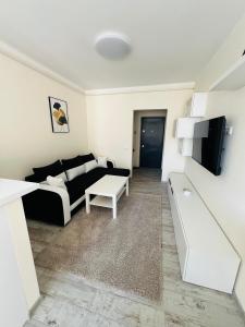 una sala de estar con un sofá y una mesa en Ivy Central Residence, en Baia Mare 9 fotos más
