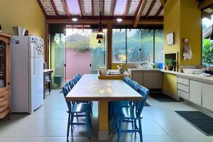 a kitchen with a wooden table and blue chairs at Casa Charme no Centro de Bonito - Condomínio Eco Bonito in Bonito