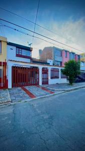 a building with a red gate on the side of a street at Apartaestudio Loft 203 - UE Home in Duitama +27 photos