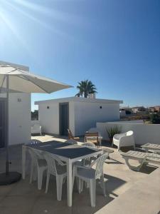 a patio with a table and chairs and an umbrella at Quinta por do sol in Quelfes