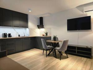 a kitchen with a table and chairs in a room at Apartament Bulvary nad Odrą in Szczecin