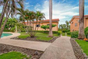 a home with palm trees and a walkway at BLA1 3 Bedroom Condo with Direct Beach Access in Tamarindo