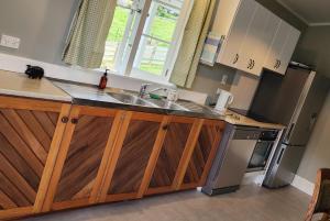 a kitchen with a sink and a refrigerator at Stuart's in Whangarei Heads