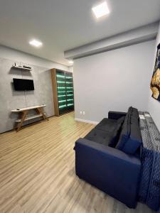 a living room with a blue couch and a table at LK Santo Agostinho 4 in Belo Horizonte