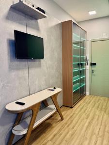 a room with a desk and a tv on a wall at LK Santo Agostinho 4 in Belo Horizonte