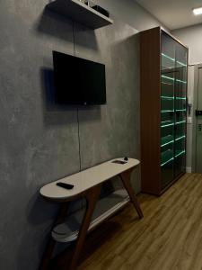 a room with a table with a tv on a wall at LK Santo Agostinho 4 in Belo Horizonte