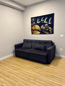 a black couch in a room with a painting on the wall at LK Santo Agostinho 4 in Belo Horizonte +20 photos