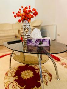 a glass table with a vase with flowers on it at Casa Otilia in Iaşi