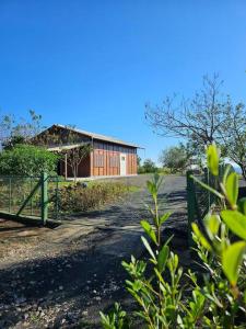 un camino de tierra con una valla y un edificio en Chácara Pôr do Sol, en Campo Alegre