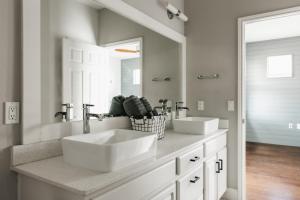 een badkamer met twee wastafels en een grote spiegel bij Modern 2-Story PoolHome with King Beds Walk to 6th St & Rainey Street in Austin +37 foto's