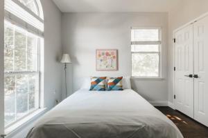 une chambre blanche avec un lit et deux fenêtres dans l'établissement 2 Story Holiday Home with Pool- Featured on TV, 3BR 3BA Beauty, à Austin
