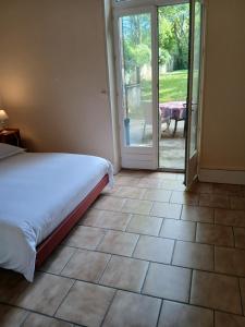 a bedroom with a bed and a sliding glass door at Château de Maucouvent in Nevers