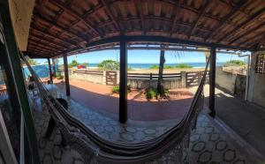 a porch with a hammock and a view of the beach at Saqua Beach Hostel in Saquarema