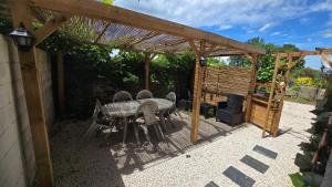 a patio with a table and chairs under a pergola at Mille et une nuit, appartement classé 3 étoiles en RDC avec exterieur et parking in Dole