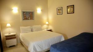 um quarto com 2 camas e 2 candeeiros na parede em Dos ambientes para tres personas em Luque