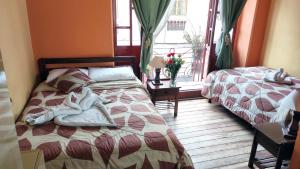 a bedroom with two beds and a window with at La Posada Colonial in Quito