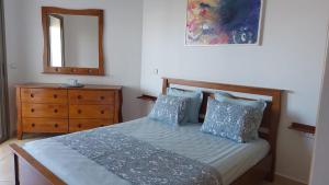 a bedroom with a bed with a dresser and a mirror at Beralmar in Asilah