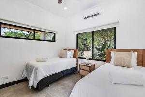 two beds in a room with two windows at CU19 New 3 Bdrm Mod Home with Casita Prv Pool in Villarreal