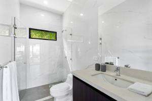 a white bathroom with a toilet and a sink at CU19 New 3 Bdrm Mod Home with Casita Prv Pool in Villarreal