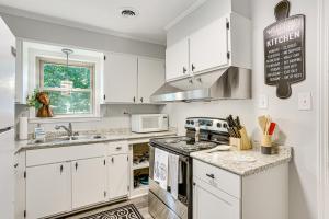 een keuken met witte kasten en een kookplaat oven bij Dandys Getaway with Fire Pit and Yard in Henderson in Henderson